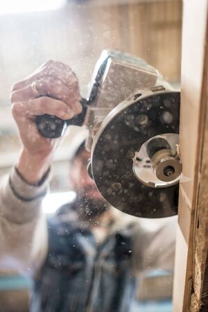 Carpenter using electric woodworking routing a wooden plankの写真素材