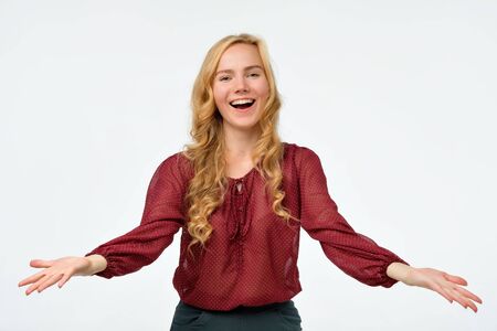 Laughing young woman spreading hands to cameraの写真素材