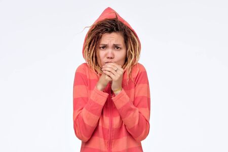 Young woman trying to get warm blowing on her hands.