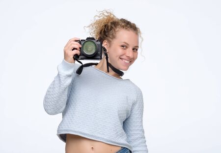 Young caucasian blonde woman with curly hair using camera.の写真素材