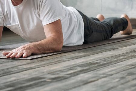 Yoga man in Cobra or sphinx pose bhujangasana variation in the gym