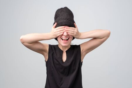 Woman closing her eyes with hand, having happy expression, recieving presentの写真素材