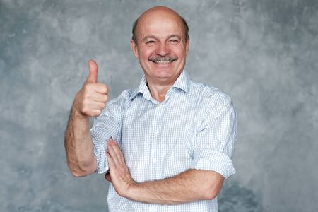 Smiling senior hispanic man wih thumb up. Positive facial human emotion.