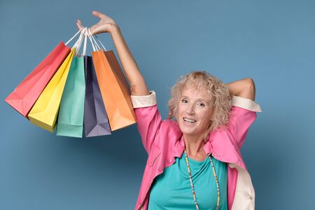 Caucasian beautiful mature woman posing with shopping bagsの写真素材