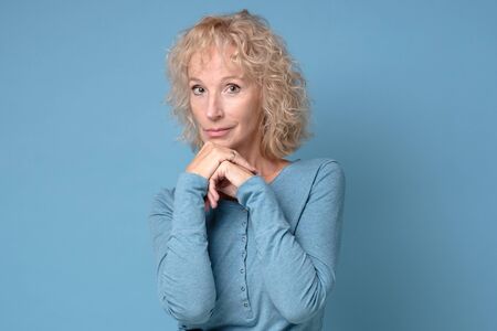 Mature blonde woman mother or wife looking confident with smile at camera.の写真素材