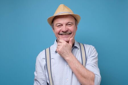 Portrait of friendly confident senior man in summer hatの写真素材