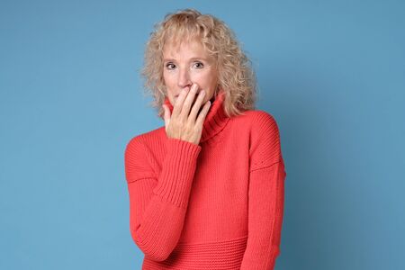 Senior woman giggles covering her mouth with handの写真素材