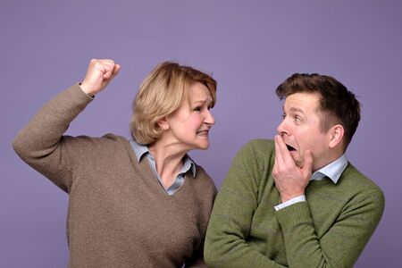 Mature mother is angry with her young son punishing him for bad decision. Studio shotの写真素材