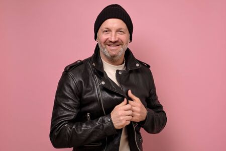 man wearing a black leather jacket and white t-shirt smiling looking at cameraの写真素材