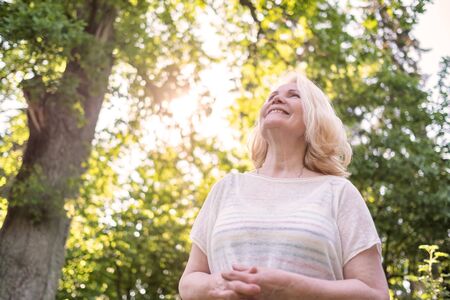 Senior caucasian woman walking in the park in summer day.の写真素材