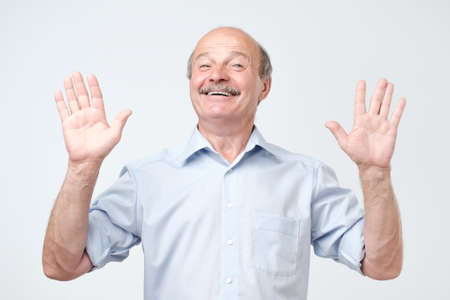 Happy smiling senior man showing ten fingers