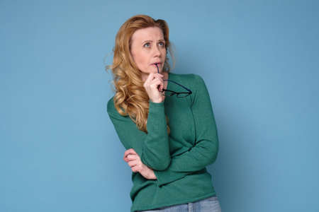 Mid adult woman contemplating looking aside planning.の写真素材