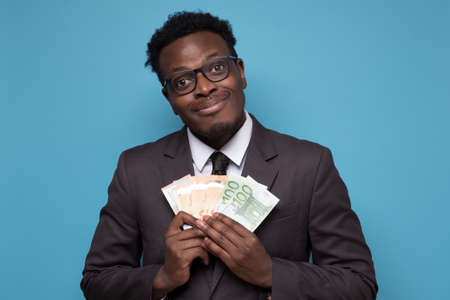 Successful and wealthy african businessman showing you moneyの写真素材