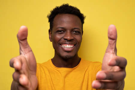 Smiling young african american man on yellow background