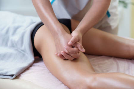 Caucasian woman getting a leg massage in the spa salon. Body care concept.の写真素材