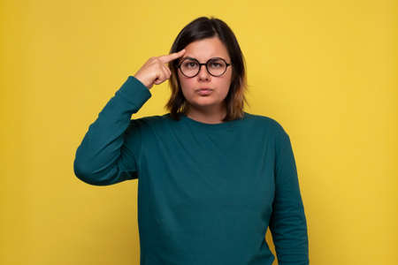 Pretty woman in glasses looking with thoughtful look making plan for tomorrow