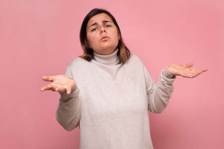 Beautiful caucasian doubtful woman shrugs her shoulders.