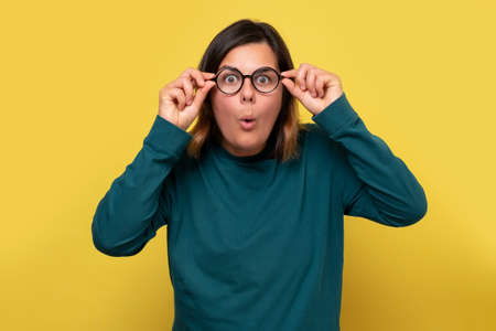 Surprised caucasian woman in glasses looking on interesting information.の写真素材
