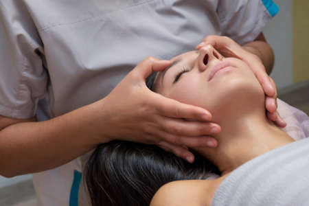 beautiful woman in massage salon receiving face massage.の写真素材
