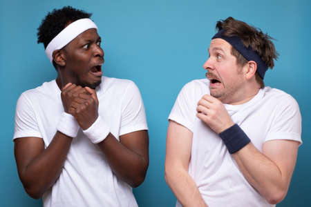 Nervous young european and african men freaking out looking at each other