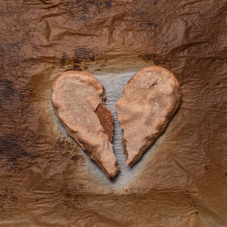close up of a broken heart made from baked beard on paper.