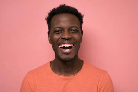 Portrait of a handsome young african man laughing on joke