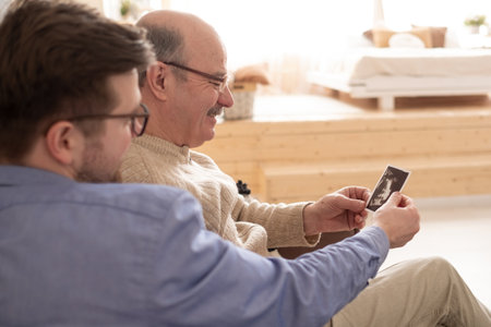 The future father and grandfather holds the ultrasound pictureの写真素材