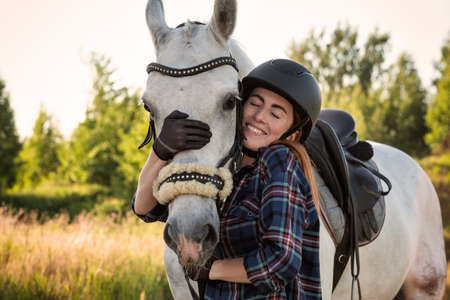 young woman taking care of her horseの写真素材