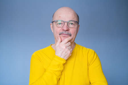 Senior bald man in glasses thinking trying to make a decision.