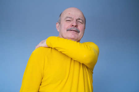 Senior hispanic man suffering from neck, shoulder pain