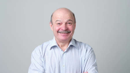 Mature adult bald man in shirt with mustache laughing looking at the camera over white background. Some jokes are old but gold. positive emotion conceptの写真素材