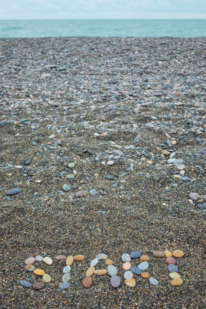 Word start made from stones on sandy beachの写真素材