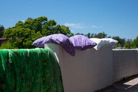 The pillows are dried on a wall after night on sunny dayの写真素材