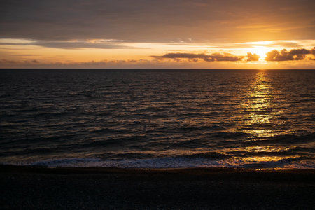 Calm sea with sunset sky and sun through the clouds over. ocean and sky background. Horizon over the water.の写真素材