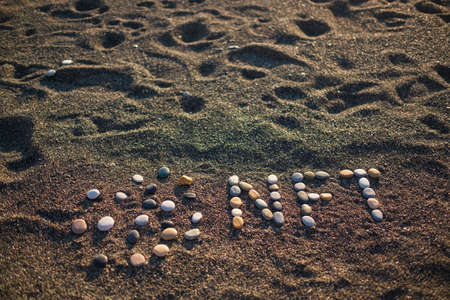 Concept of non-fungible NFT tokens. NFT text made from stones on beachの写真素材