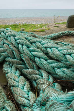 Old rope on the beach. vertical orientation. beach pollutionの写真素材
