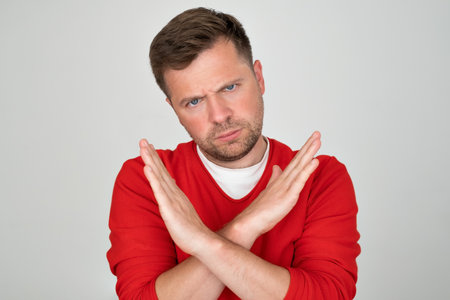 Mature man looking serious showing open palm making stop gestureの写真素材