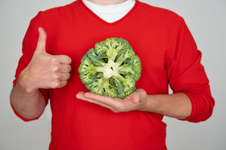 Man holding green fresh broccoli, isolated on white backgroundの写真素材