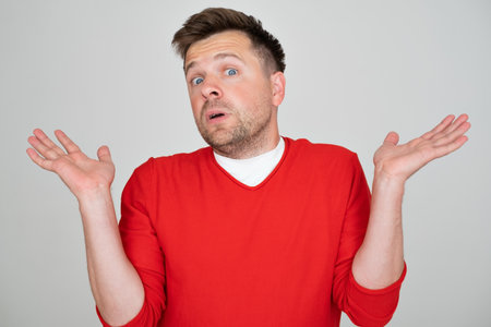 Man clueless and confused expression with arms and hands raised.の写真素材