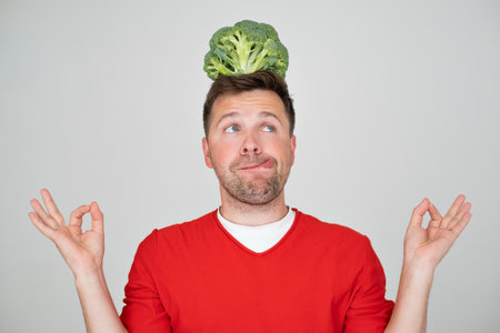 Man holding green fresh broccoli, isolated on white backgroundの写真素材
