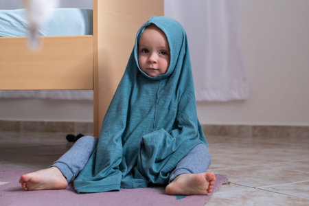 Cute baby girl dressing herself at her mother t-shirt.の写真素材