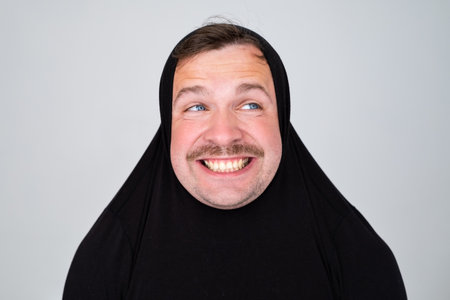 Funny caucasian man covering head with sweater smiling cheerful and funny.の写真素材