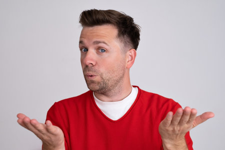 man clueless and confused expression with arms and hands raised.の写真素材
