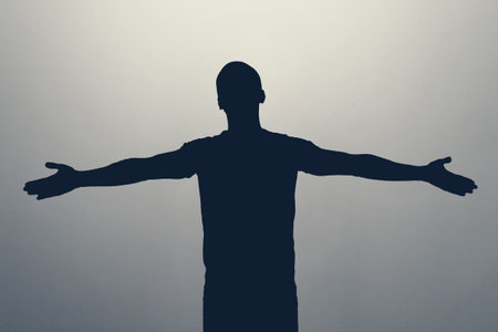 Silhouette of a person with arms outstretchedの写真素材
