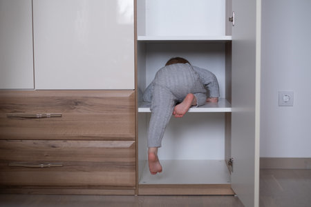 happy girl playing hide and seek in wardrobeの写真素材