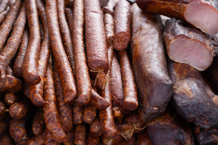 Homemade sausages of pork smoked and dried stand on the table for sale.の写真素材