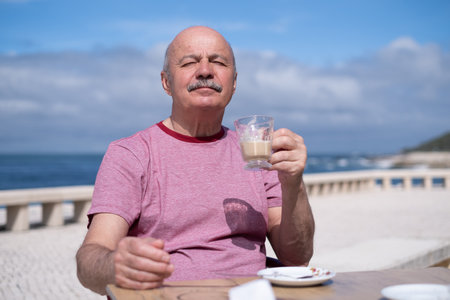 Elderly Man with Mustache Drinking Coffee at Outdoor Cafe on Vacation