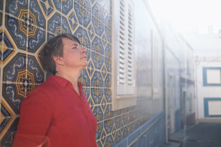 Woman enjoying the moment by a traditional Portuguese tiled wallの写真素材