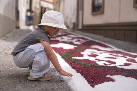 Girl looking at a traditional colorful carpet in Portugal during a festivalの写真素材