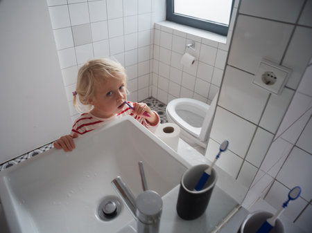 Little 4-year-old girl learning to brush her teeth by herself at homeの写真素材